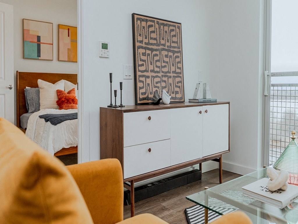 a living room with a couch and a dresser and a bed